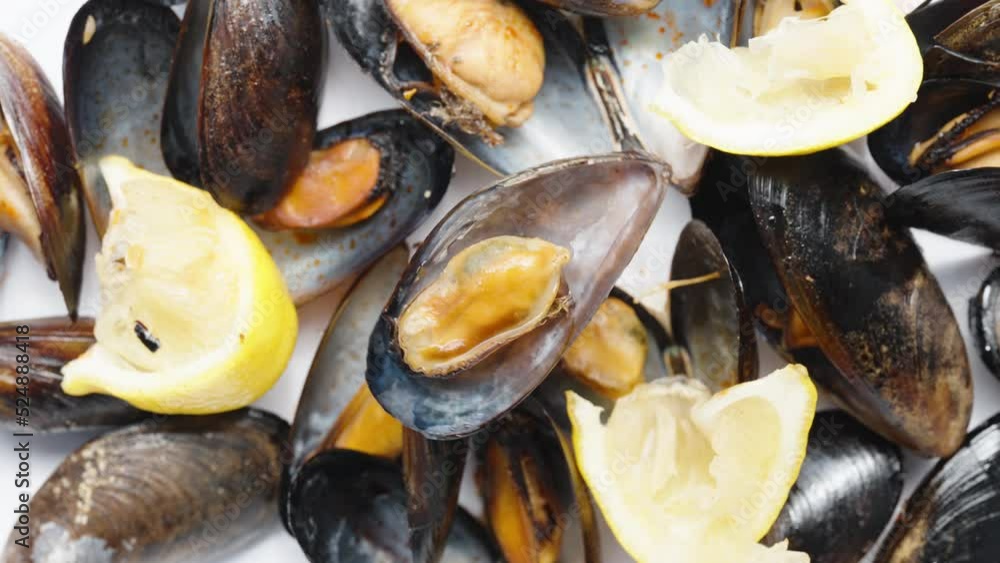 An open shell with a mussel rotates against the background of other and lemon. An open shell with a mussel rotates against the background of other and lemon.