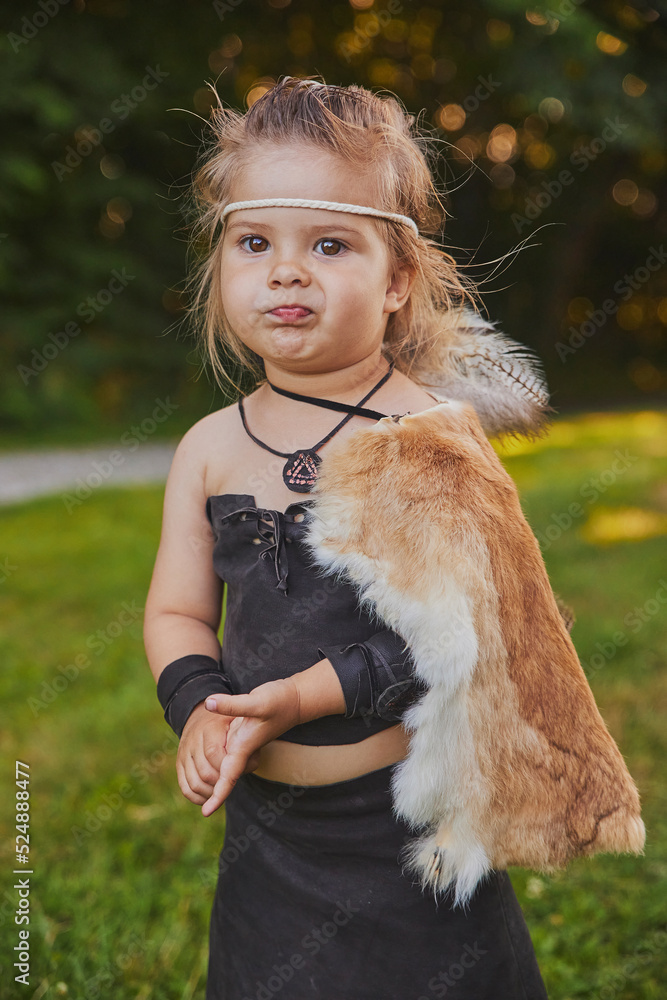Funny baby dressed in the clothes of primitive people Funny baby dressed in the clothes of primitive people