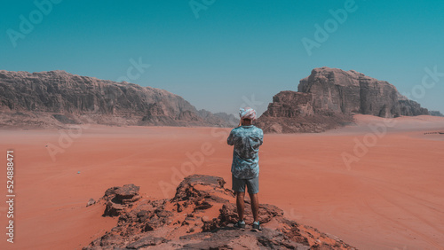 Tourist observes the panorama in the desert Wadi Rum, Jordan