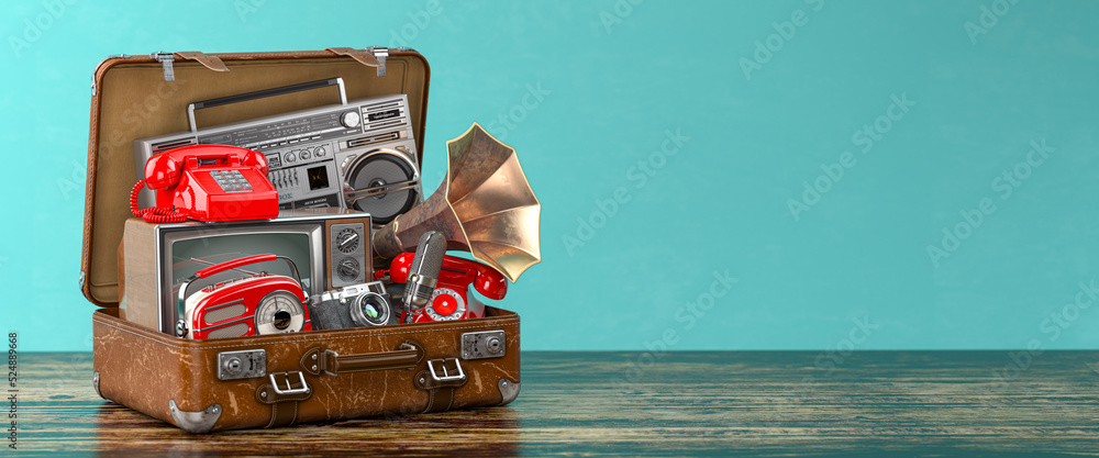 Vintage electrical and electronic appliances in an old suitcase. Nostalgic retro objects from the past 1960s - 1980s on green backgound. - obrazy, fototapety, plakaty 