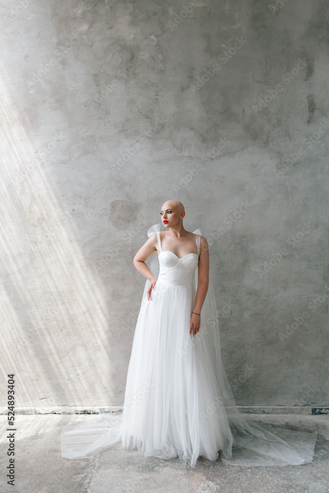 Bald beautiful bride in a luxurious wedding dress in red lipstick and a long veil is sick with cancer Bald beautiful bride in a luxurious wedding dress in red lipstick and a long veil is sick with cancer