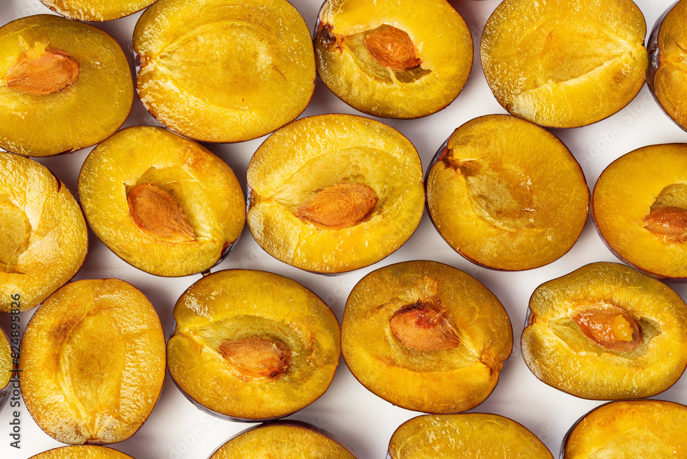 Fruit pattern of sliced halves of ripe plums Fruit pattern of sliced halves of ripe plums