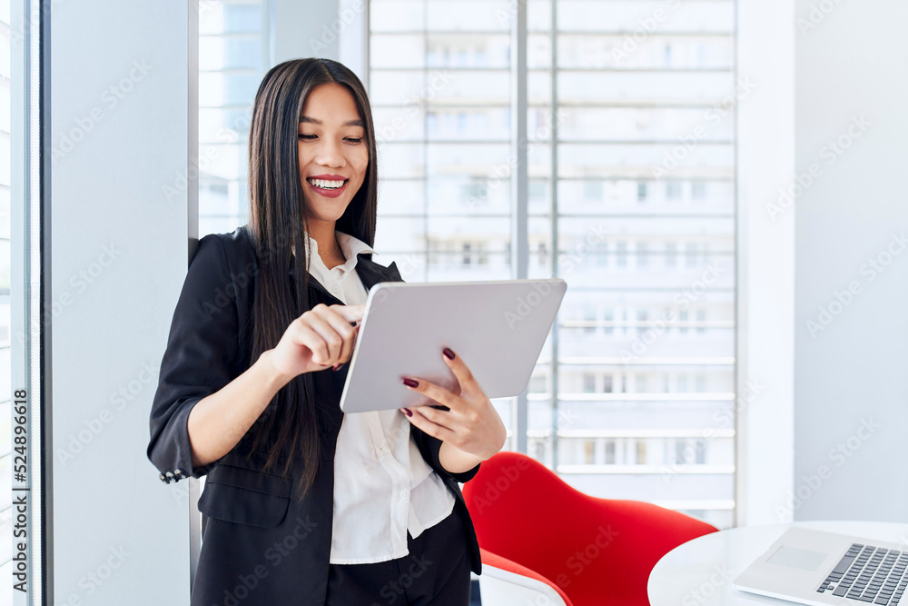 Happy asian businesswoman using digital tablet at office Happy asian businesswoman using digital tablet at office