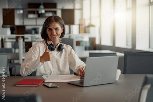 Attractive european business woman working laptop while sitting in cozy cafe. Blurred background