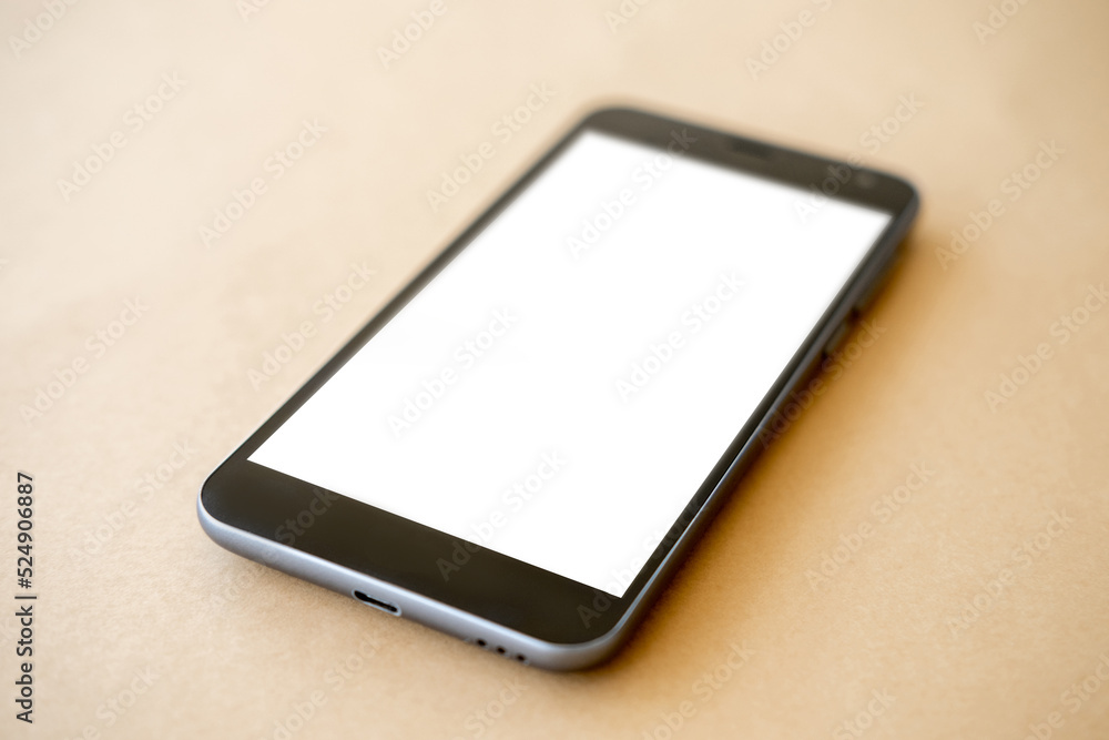 Mobile technology. Digital mockup. Online connection. Smartphone with white blank screen laying beige table.