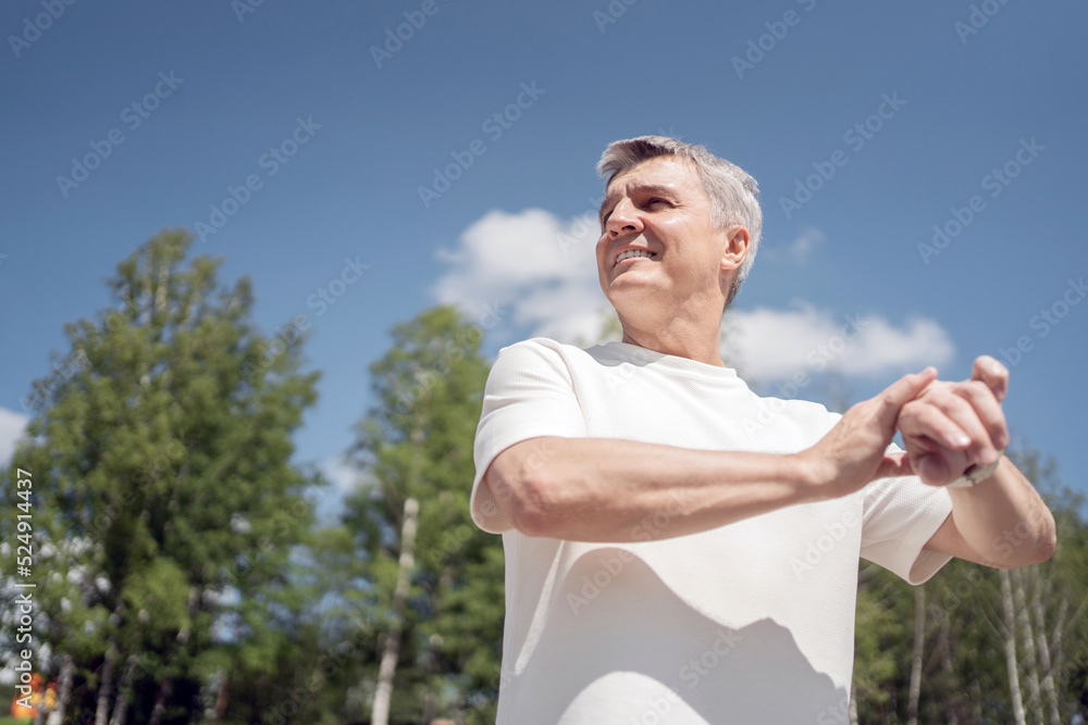 A retired man uses a fitness watch, a sporty man does a workout in the park. A retired man uses a fitness watch, a sporty man does a workout in the park.