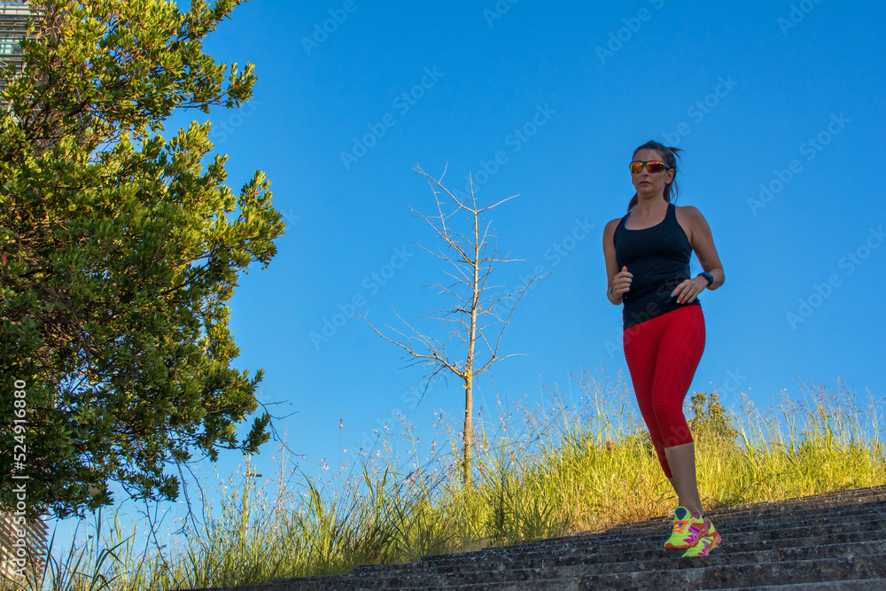 Beautiful young woman exercising for her daily workout. Mature woman running at sunset. Sporty woman and physical activity. Beautiful young woman exercising for her daily workout. Mature woman running at sunset. Sporty woman and physical activity.
