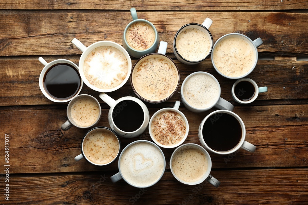 Many cups of different coffees on wooden table, flat lay Many cups of different coffees on wooden table, flat lay