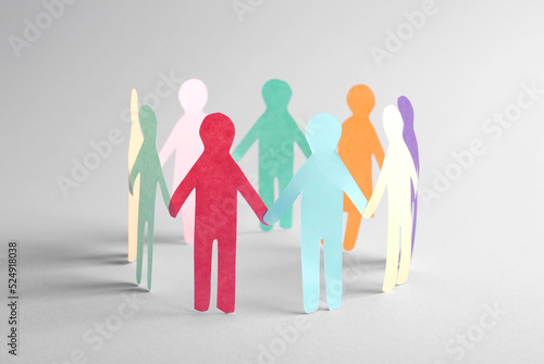 Paper human figures making circle on white background. Diversity and Inclusion concept photo