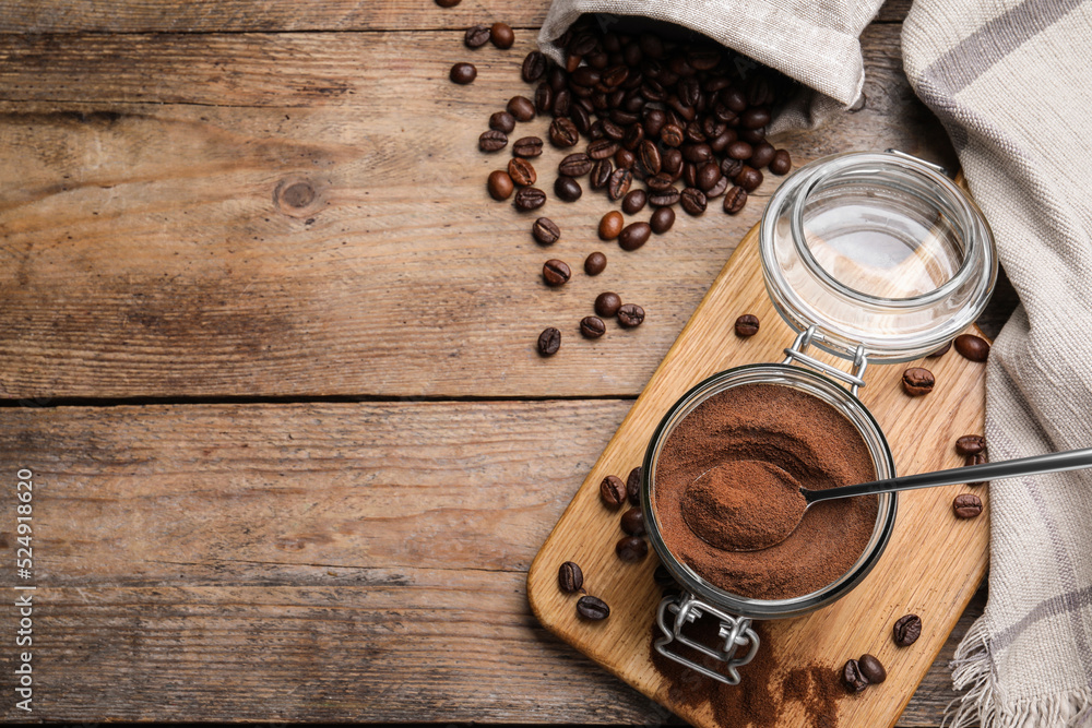 Glass jar of instant coffee and spoon on wooden table, flat lay. Space for text Glass jar of instant coffee and spoon on wooden table, flat lay. Space for text