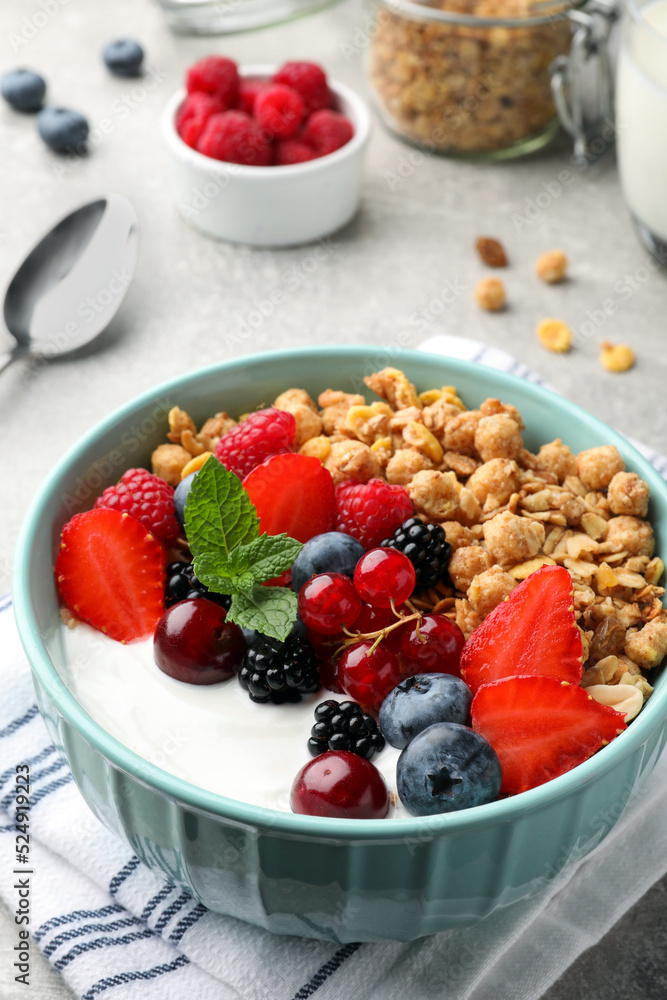 Bowl with tasty granola and berries on light grey table. Healthy meal Bowl with tasty granola and berries on light grey table. Healthy meal