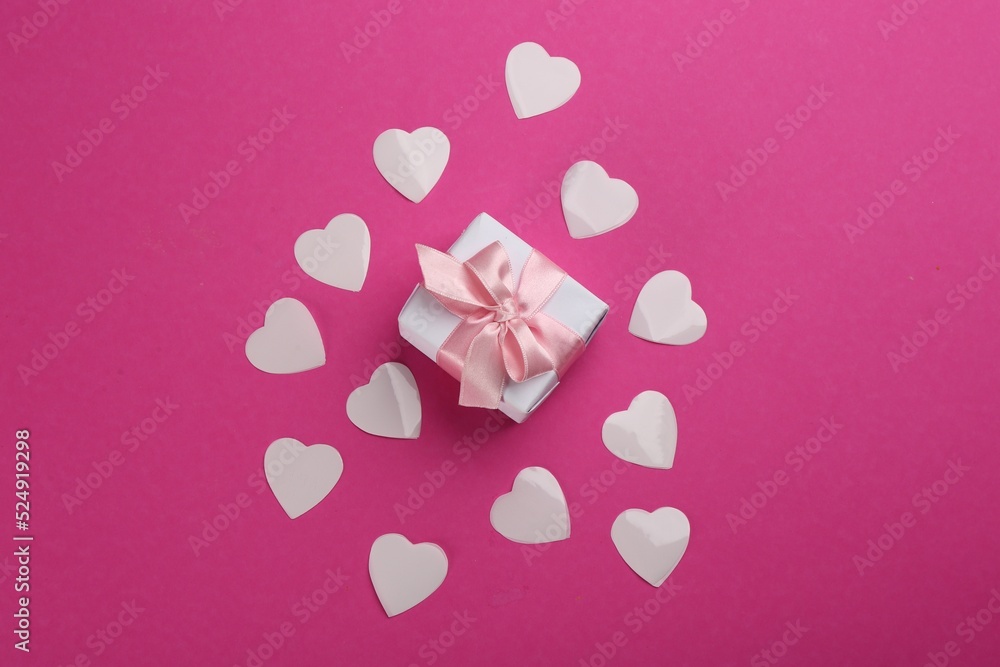 Beautiful gift box and hearts on pink background, flat lay. Valentine's day celebration