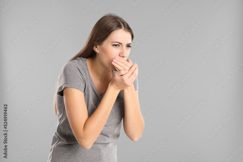 Woman suffering from nausea on grey background, space for text. Food poisoning Woman suffering from nausea on grey background, space for text. Food poisoning
