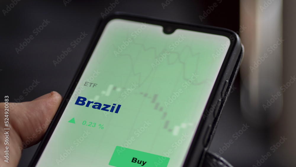 An investor's analyzing the Brazil etf fund on screen. A phone shows the ETF's prices Brazilian brazil brazilian to invest An investor's analyzing the Brazil etf fund on screen. A phone shows the ETF's prices Brazilian brazil brazilian to invest