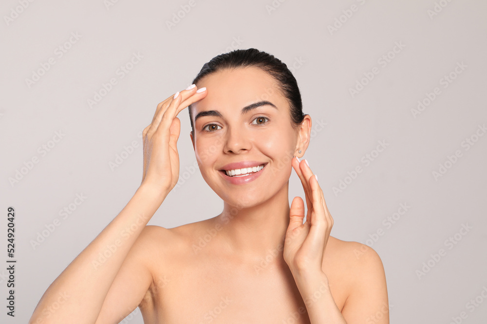 Beautiful young woman with perfect skin on light grey background Beautiful young woman with perfect skin on light grey background