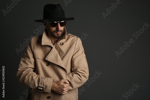 Exhibitionist in coat and hat on black background. Space for text
