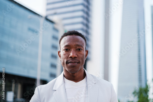 Extreme close-up portrait of young man in white suit in financial district