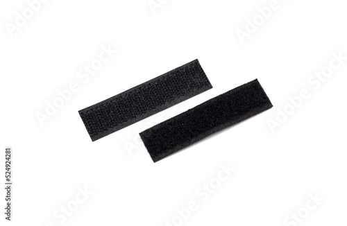 Two pieces of black velcro, photographed diagonally on a white background.