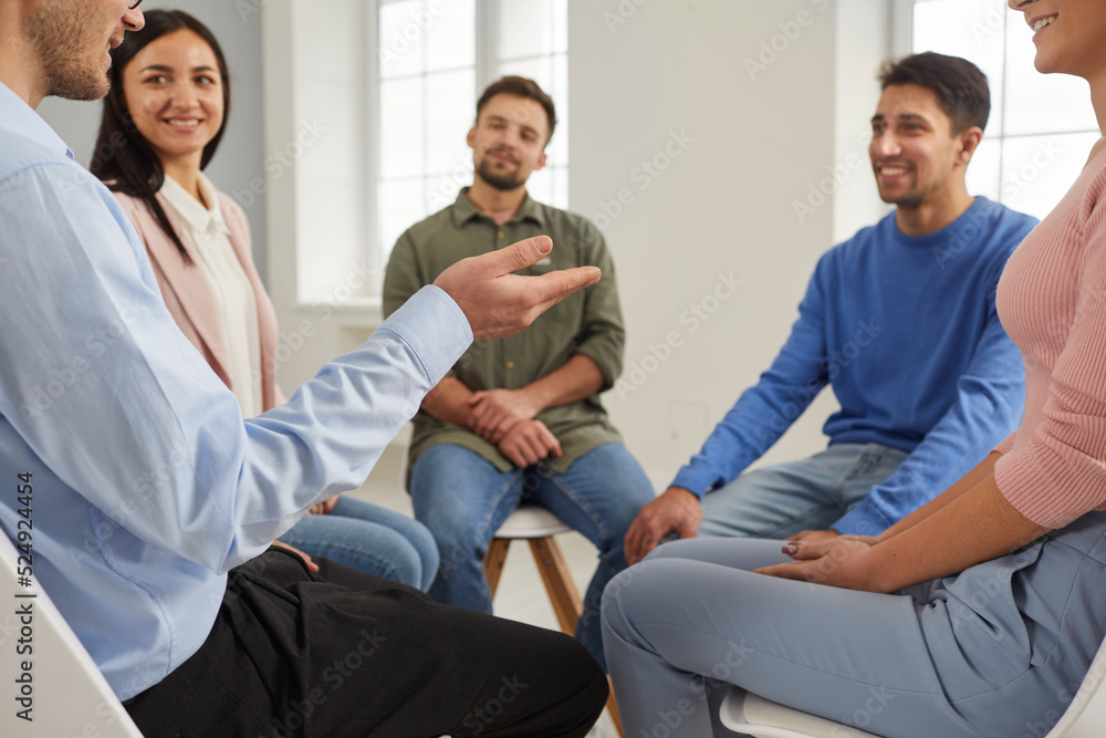 Group of people having a discussion during a business meeting in the office. Team of happy smiling employees sitting in a circle and talking. Young men and women discussing something in group therapy Group of people having a discussion during a business meeting in the office. Team of happy smiling employees sitting in a circle and talking. Young men and women discussing something in group therapy