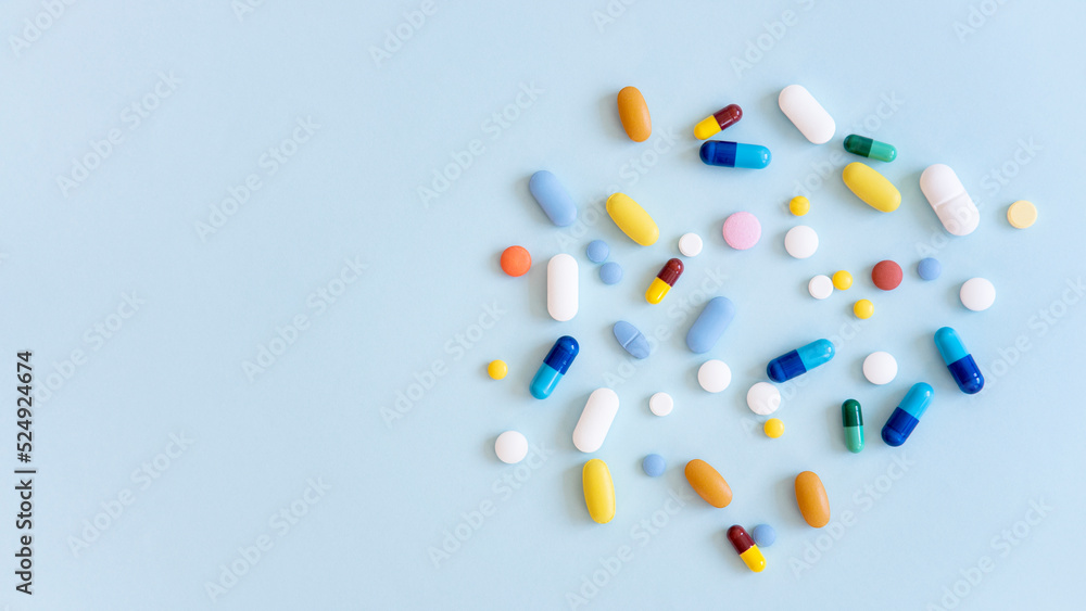 Assorted pharmaceutical medicine pills, tablets and capsules over blue background Assorted pharmaceutical medicine pills, tablets and capsules over blue background