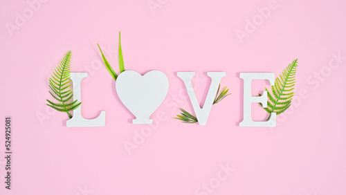 Wallpaper Mural Love letters with green leaves decorated on pastel pink background. Flat lay Torontodigital.ca