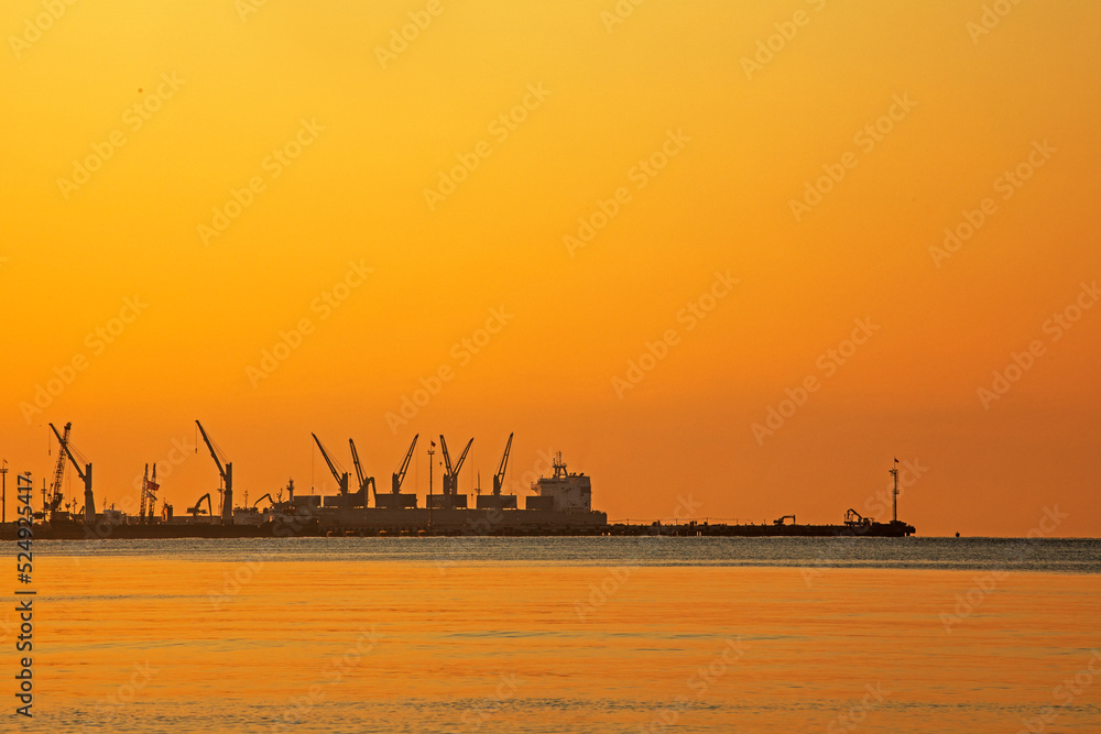 port at dawn on the sea against the background of an orange sky. landscape