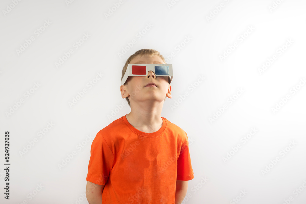 a boy in an orange T-shirt and 3 d glasses on white background. a boy in an orange T-shirt and 3 d glasses on white background.