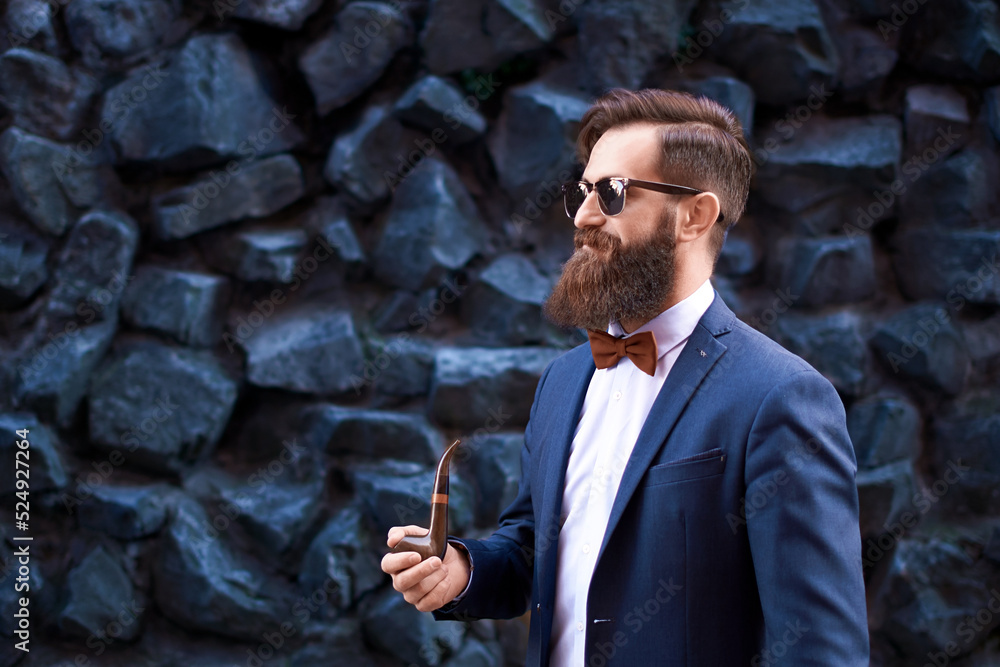 Stylish man with beard wearing a jacket, shirt and bow tie