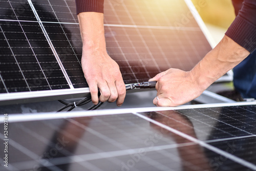 Connecting solar panels to each other. Rooftop solar power system mount. Turnkey solar power system, service works. Green energy