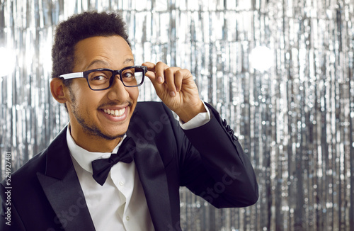 Print op canvas Happy charismatic handsome black guy in modern tux suit, glasses and bow tie having fun at party