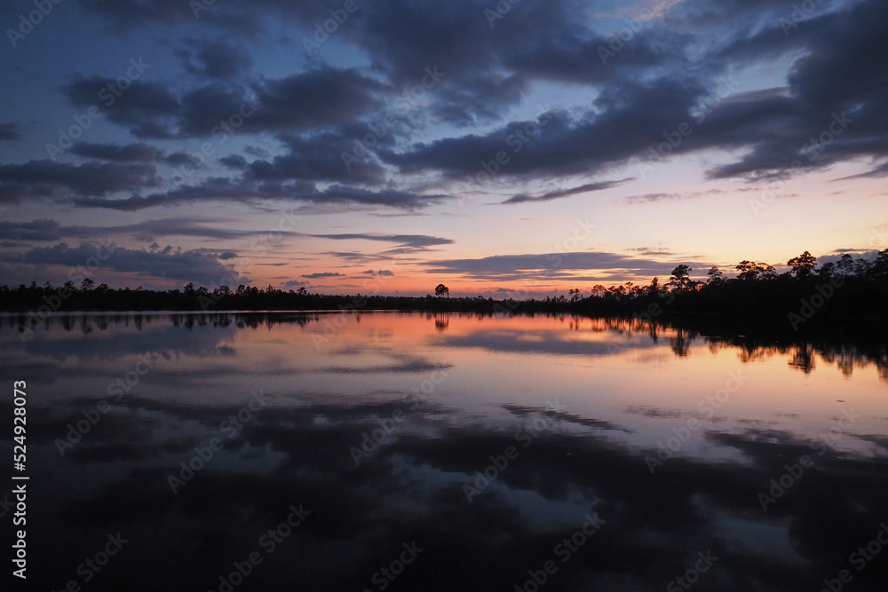 Colorful summer sunset cloudscape over Pine Glades Lake reflected in calm water of Everglades National Park, Florida. Colorful summer sunset cloudscape over Pine Glades Lake reflected in calm water of Everglades National Park, Florida.