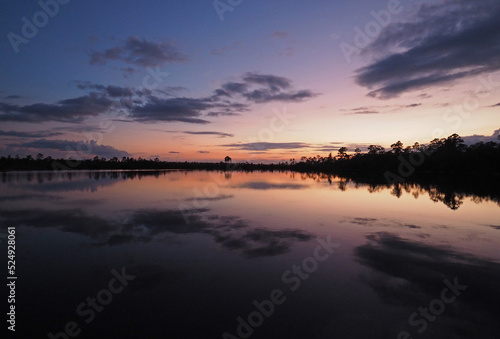 Colorful summer sunset cloudscape over Pine Glades Lake reflected in calm water of Everglades National Park, Florida. © Francisco