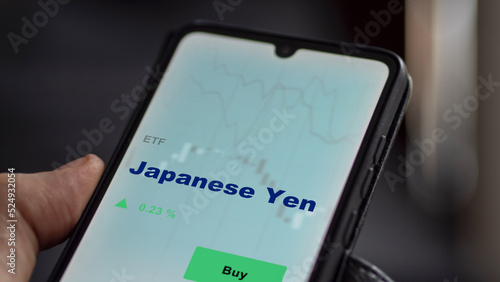 September 13th 2022, London UK. An investor's analyzing the Japanese Yen etf fund on screen. A phone shows the currency of Japan ETF's prices invest