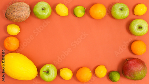 Creative copy space frame with citrus fruits on dark orange background. Flat lay