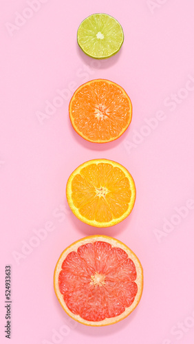 Creative summer fruits pastel pink background with sliced citrus. Flat lay