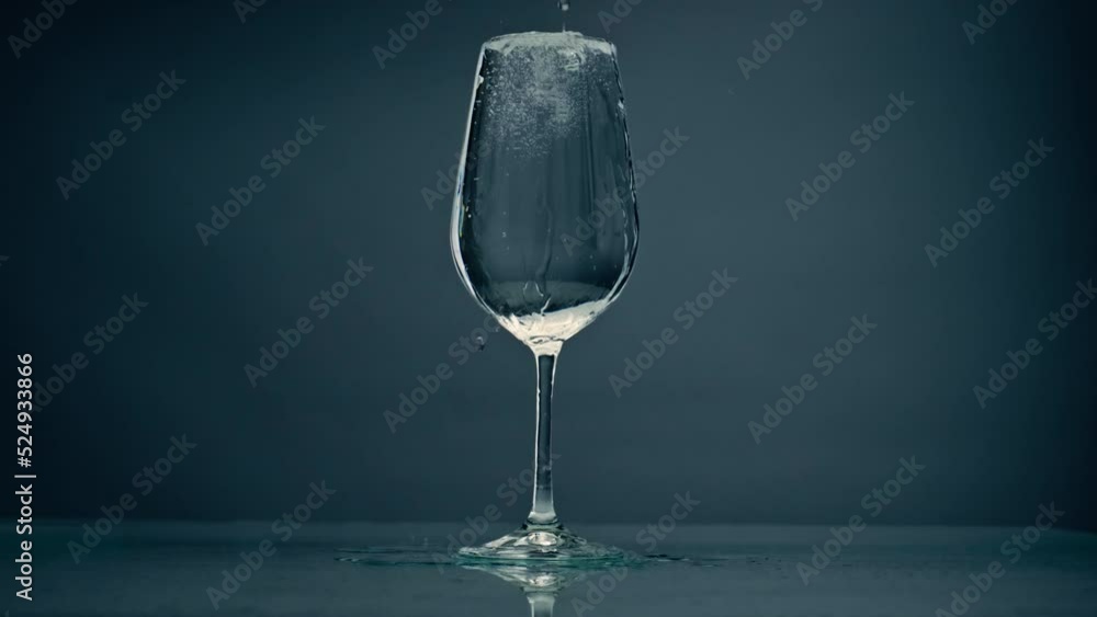 Pure water overflowing glass closeup. Cool refreshing liquid spilling wine  cup
