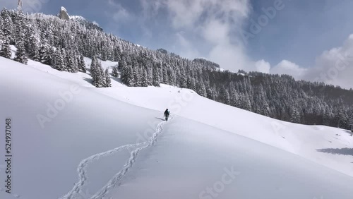 Lone man walking through snow. Mountain expedition. Epic Aerial steady view