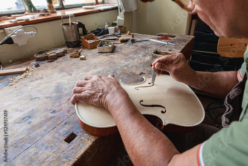 Bild auf Leinwand luthier carving and sculpting the f holes a violin with a knife