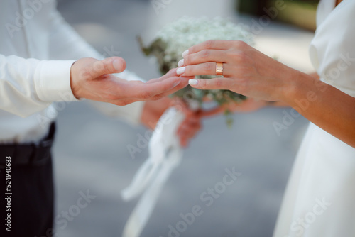 Wedding bouquet in the hands of the bride at the ceremony. Touching the hands of the bride and groom. Wedding jewelry. Wedding rings. The tenderness and beauty of the wedding ceremony.