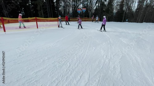 Skiers going downhill in a ski resort, active rest in winter mountains, extreme shooting in motion