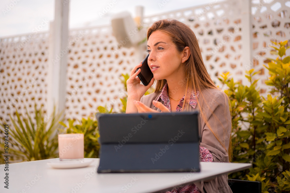 An executive woman and businesswoman having breakfast in a restaurant talking on the phone a work call An executive woman and businesswoman having breakfast in a restaurant talking on the phone a work call