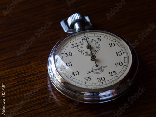 Retro stopwatch is on a wooden table