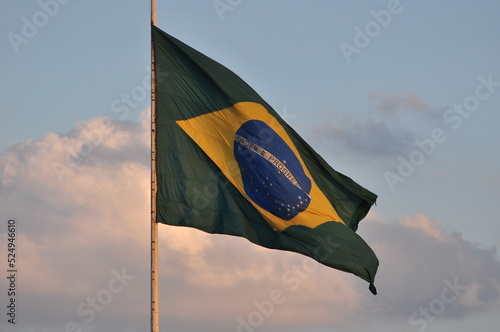 A bandeira brasileira tremulando no céu vespertino do Brasil photo