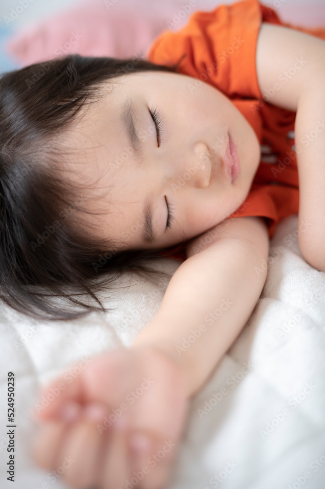布団でお昼寝している2歳の女の子 布団でお昼寝している2歳の女の子