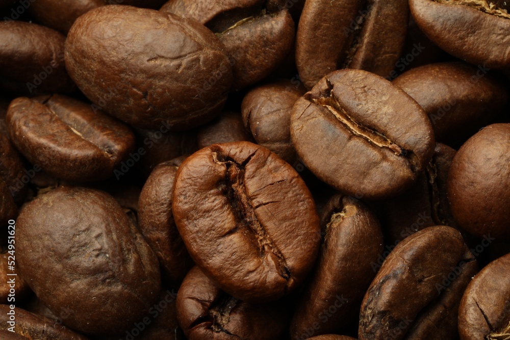 Naklejka premium Pile of roasted coffee beans as background, closeup