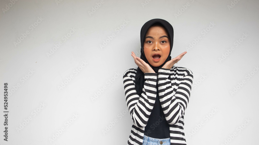 Surprised Asian woman reclines on her hands and shouting while looking at the camera over whitebackground Surprised Asian woman reclines on her hands and shouting while looking at the camera over whitebackground