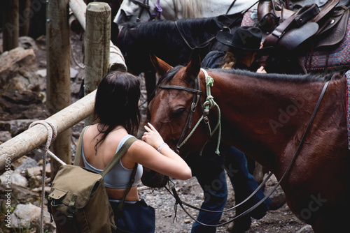 Young girl petting horse on a trail tour in Banff
