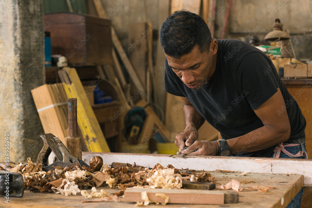 Entrepreneurial man doing his daily chores. Carpenter polishing wood