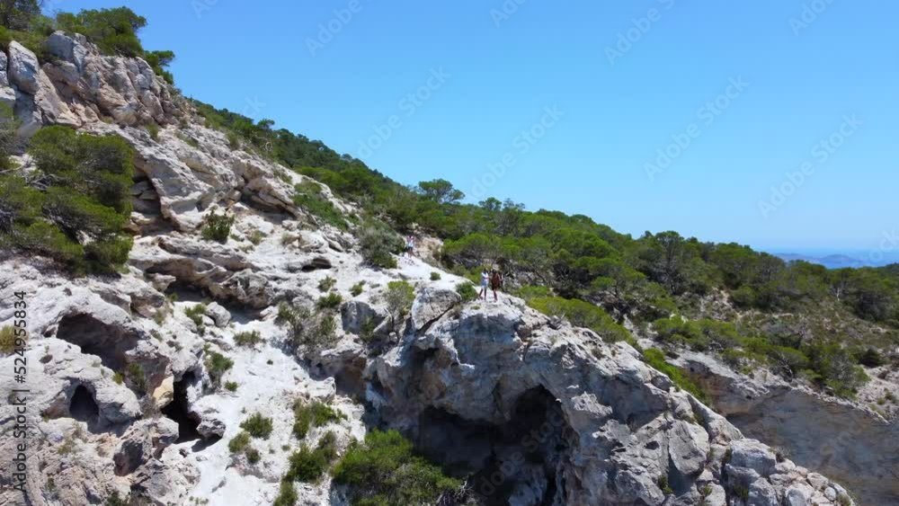 2 person do a dangerous walk in the mountain on west Ibiza.Beautiful aerial view flight fly forward drone footageof cliff edges hike Ibiza summer 2022. 2 person do a dangerous walk in the mountain on west Ibiza.Beautiful aerial view flight fly forward drone footageof cliff edges hike Ibiza summer 2022.