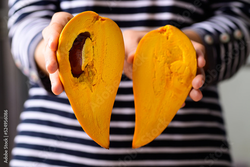 Canistel fruit or Eggfruit holding by woman hand, Tropical fruit